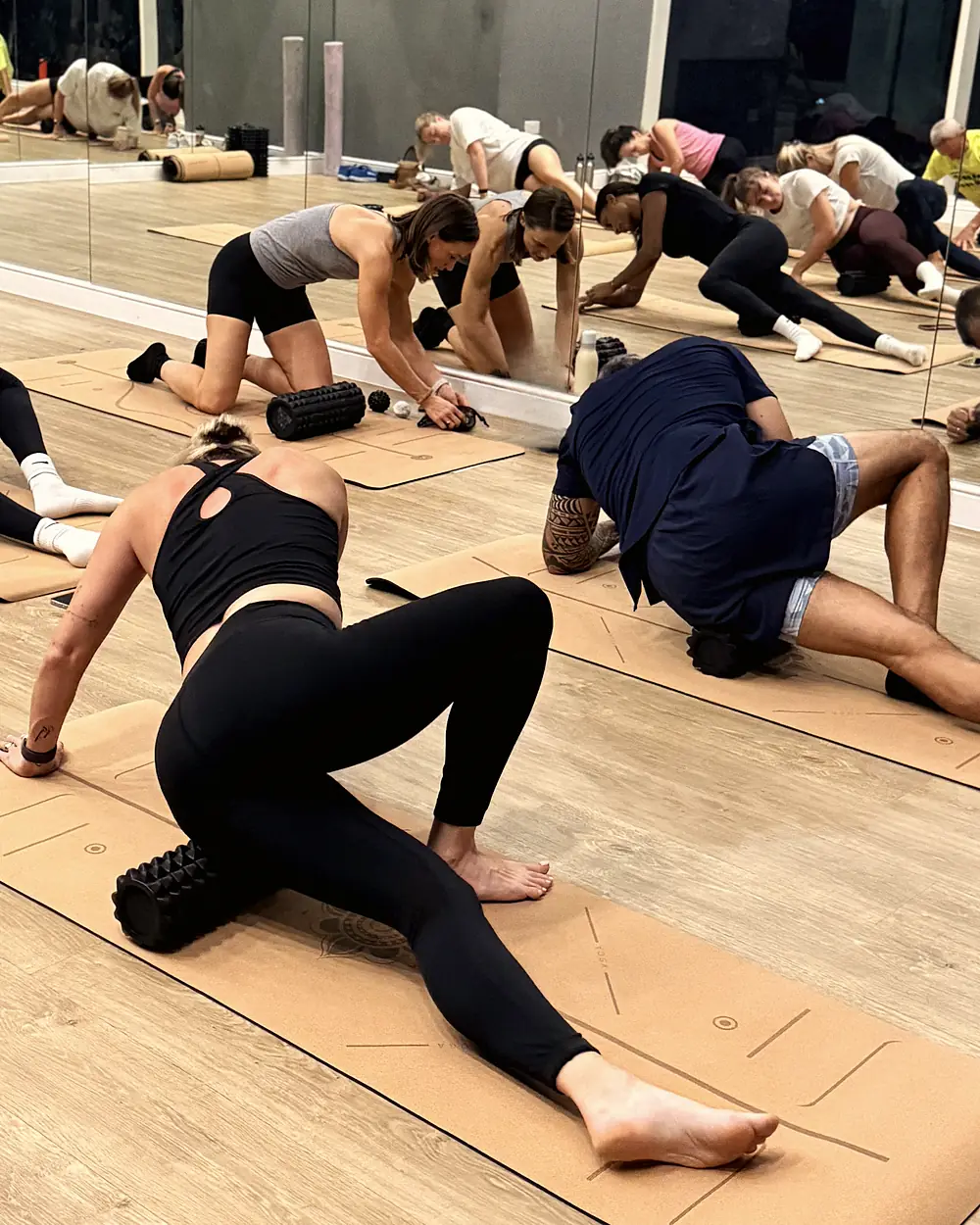 An athlete working a foam roller along her outer hip